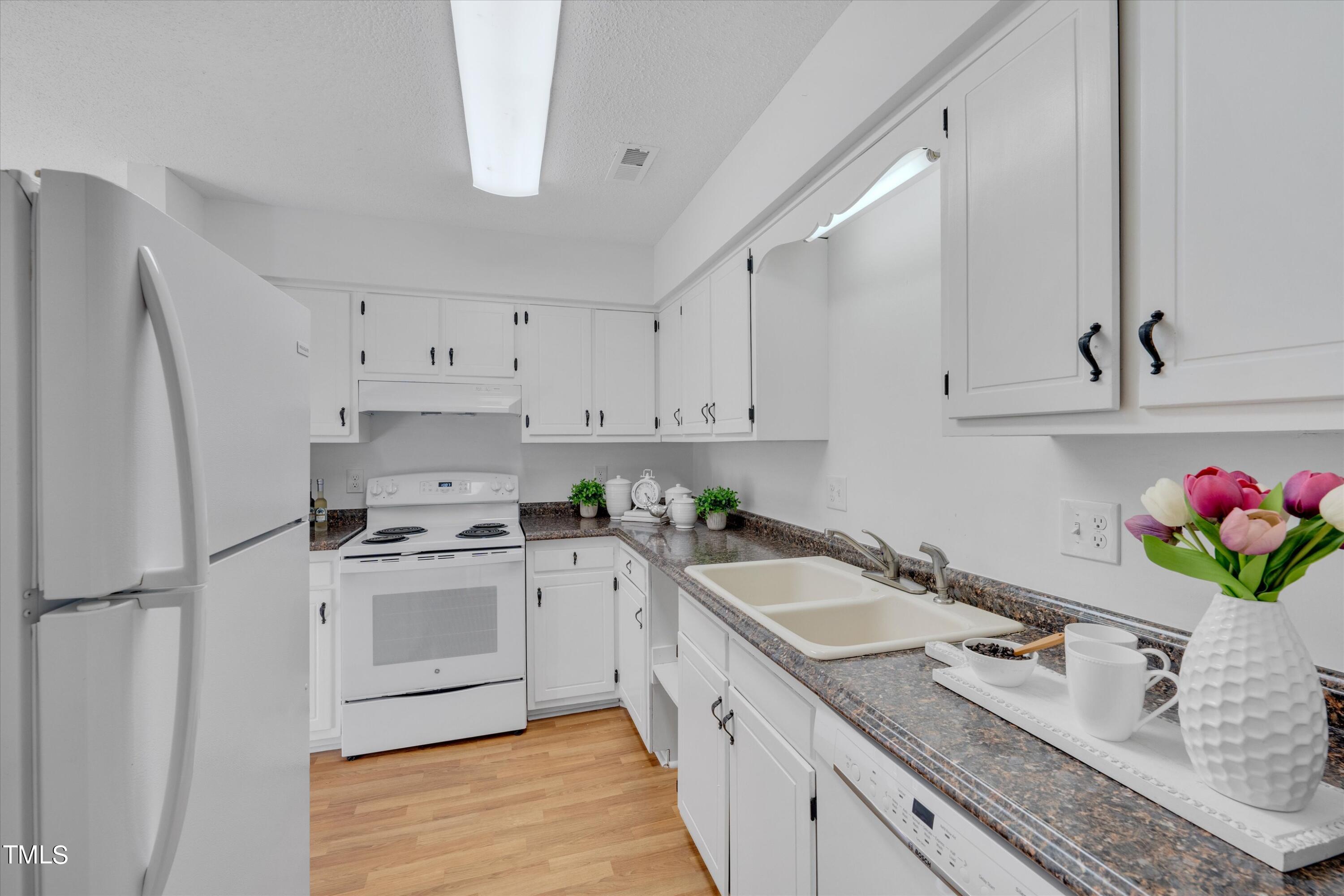 617 Pine Ridge Place Raleigh, NC 27609 - Photo 4 of 18 a kitchen with a sink stove and refrigerator