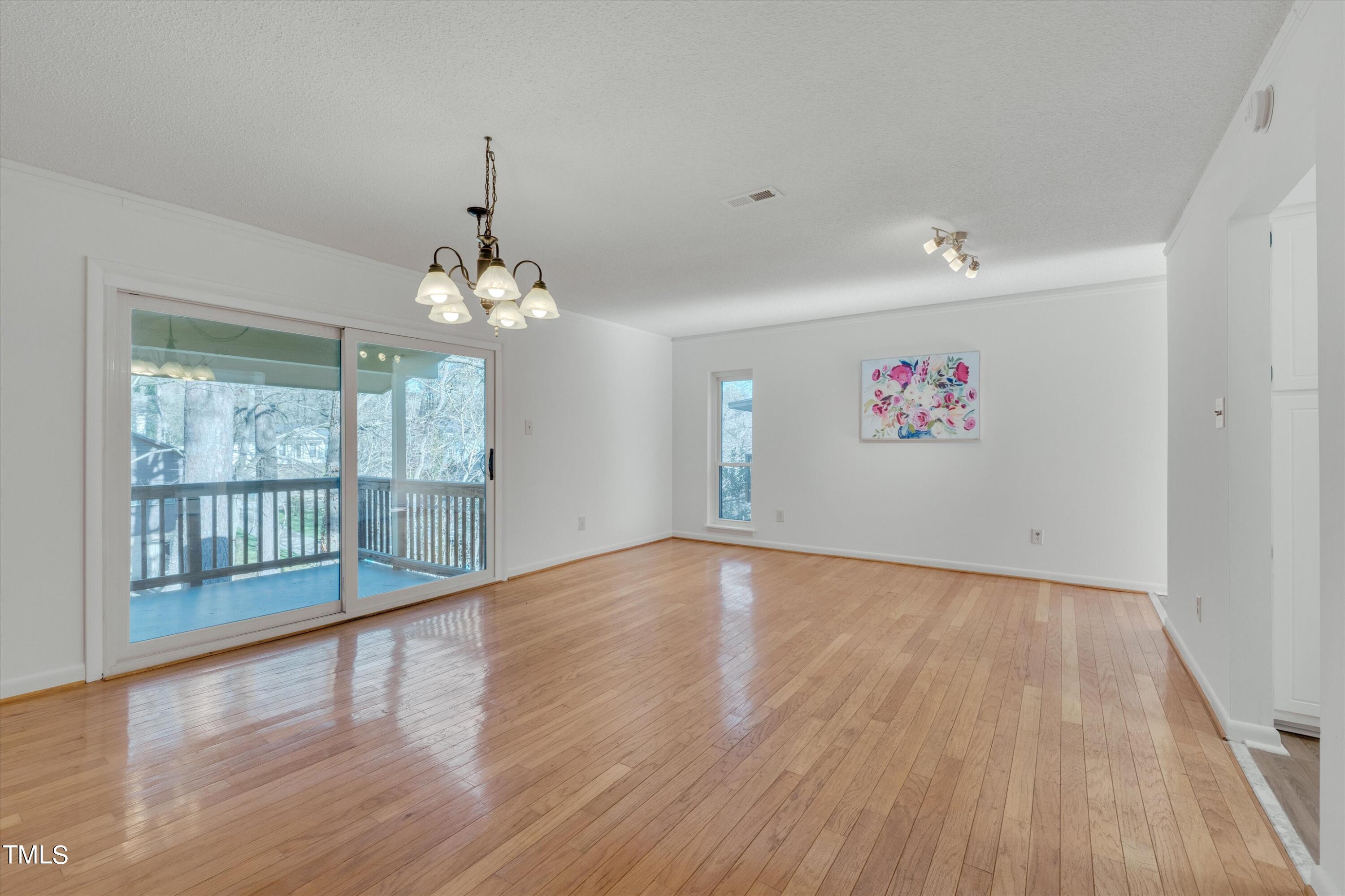 617 Pine Ridge Place Raleigh, NC 27609 - Photo 6 of 18 a view of an empty room with wooden floor and a window