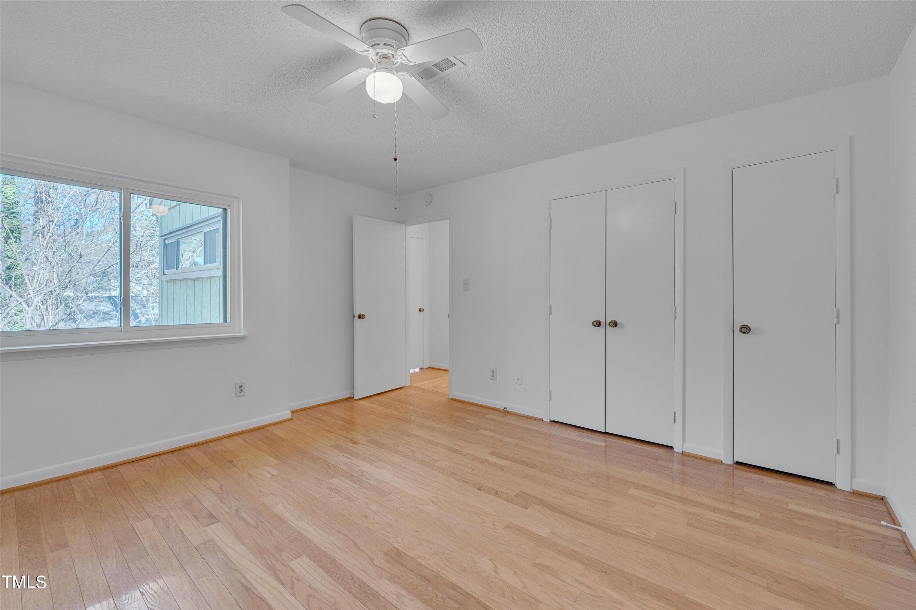 617 Pine Ridge Place Raleigh, NC 27609 - Photo 9 of 18 a view of empty room with wooden floor and ceiling fan