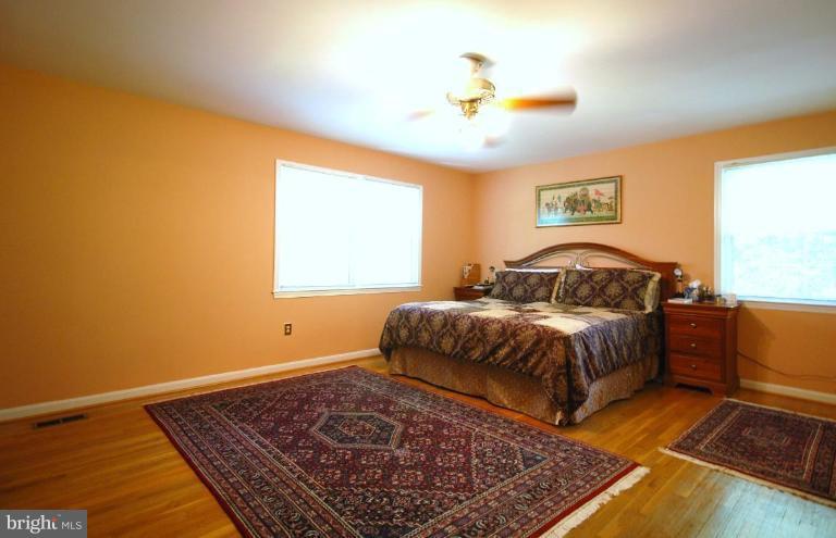 10728 Midsummer Drive Reston, VA 20191 - Photo 14 of 21 a bedroom with a bed and wooden floor