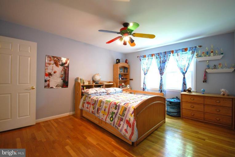10728 Midsummer Drive Reston, VA 20191 - Photo 16 of 21 a bedroom with a bed and a chandelier