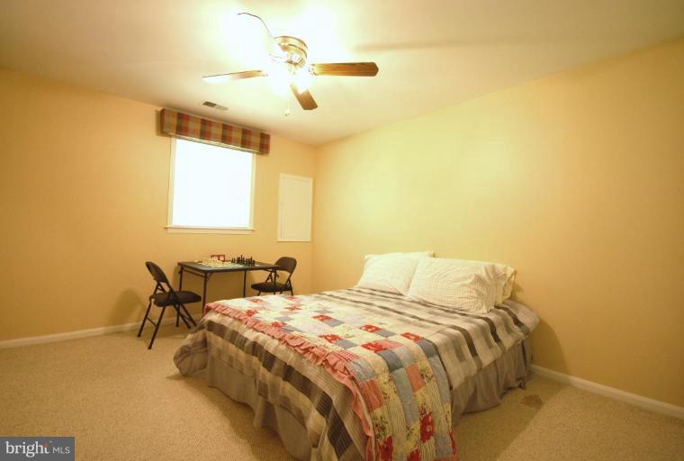 10728 Midsummer Drive Reston, VA 20191 - Photo 19 of 21 a bedroom with a bed and a chandelier