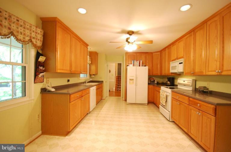 10728 Midsummer Drive Reston, VA 20191 - Photo 8 of 21 a large kitchen with stainless steel appliances kitchen island granite countertop a refrigerator a stove top oven a sink and dishwasher