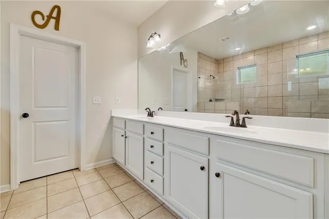 a spacious bathroom with double sink and a mirror