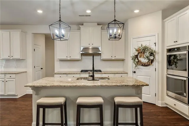 a kitchen with stainless steel appliances granite countertop a sink and a refrigerator