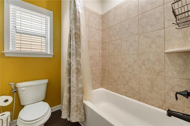 a white toilet sitting next to a white bath tub