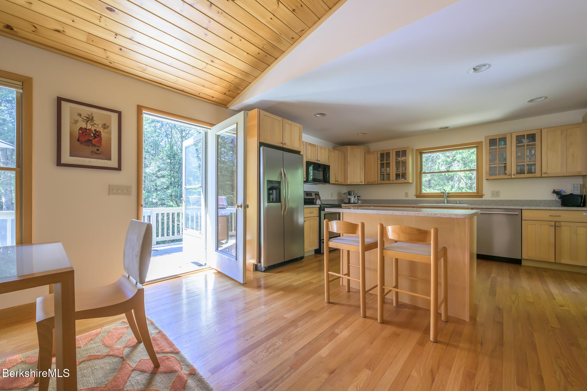545 West Center Road Otis, MA 01253 - Photo 17 of 60 a kitchen with stainless steel appliances granite countertop a stove top oven a sink dishwasher a dining table and chairs with wooden floor