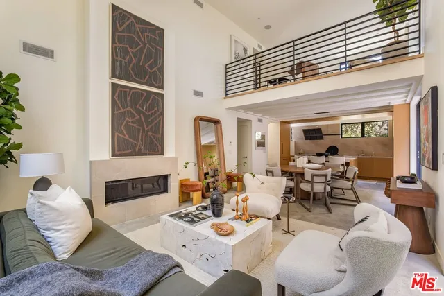 a living room with furniture kitchen view and a large window
