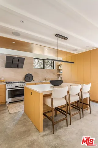 a kitchen with stainless steel appliances kitchen island a table and chairs in it