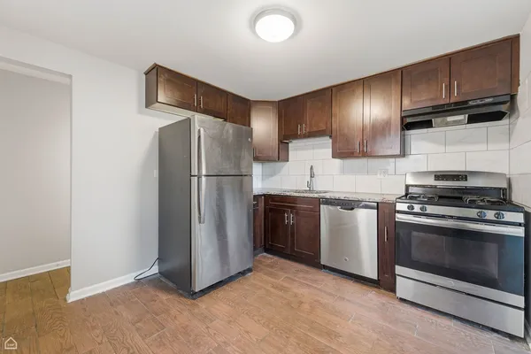 a kitchen with stainless steel appliances granite countertop a refrigerator a stove and a sink