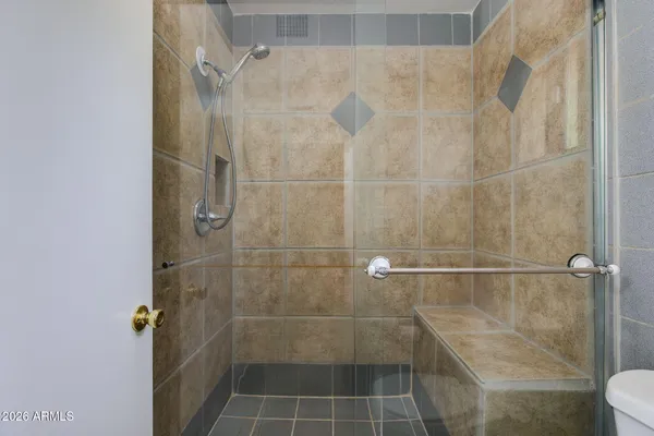 a bathroom with a granite countertop sink toilet a mirror and shower