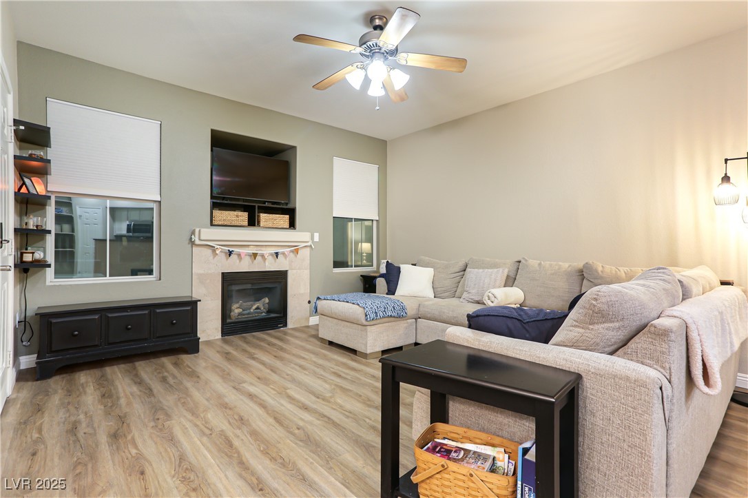 10550 West Alexander Road, Unit 1068 Las Vegas, NV 89129 - Photo 4 of 28 Living room with wood finished floors, a ceiling fan, and a fireplace