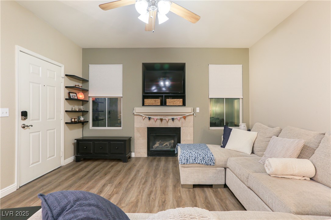 10550 West Alexander Road, Unit 1068 Las Vegas, NV 89129 - Photo 5 of 28 Living area featuring a ceiling fan, wood finished floors, and a fireplace