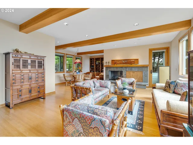 a living room with furniture a flat screen tv and floor to ceiling window