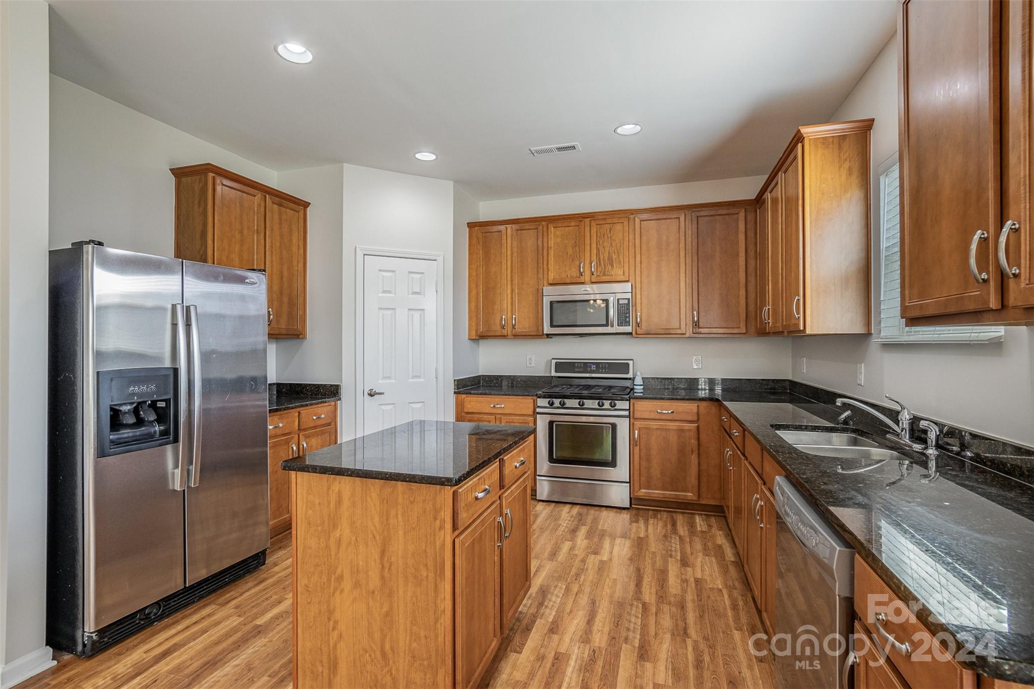 7006 Farm Pond Road Indian Trail, NC 28079 - Photo 6 of 37 a kitchen with stainless steel appliances granite countertop a refrigerator a stove top oven a sink and dishwasher