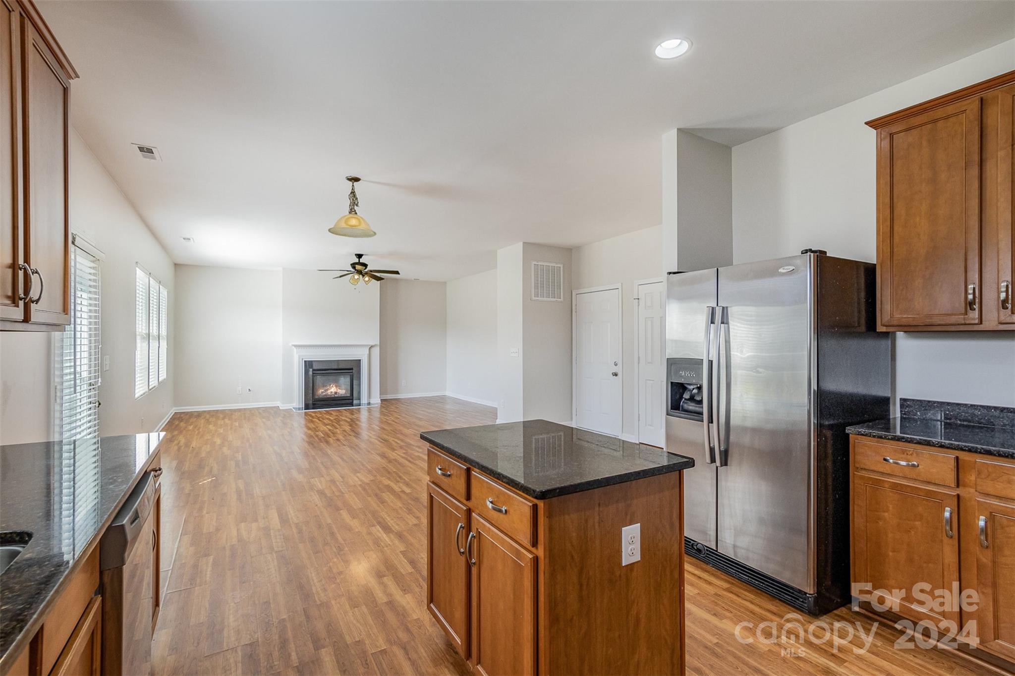 7006 Farm Pond Road Indian Trail, NC 28079 - Photo 7 of 37 a kitchen with stainless steel appliances granite countertop a refrigerator a stove and a wooden floors