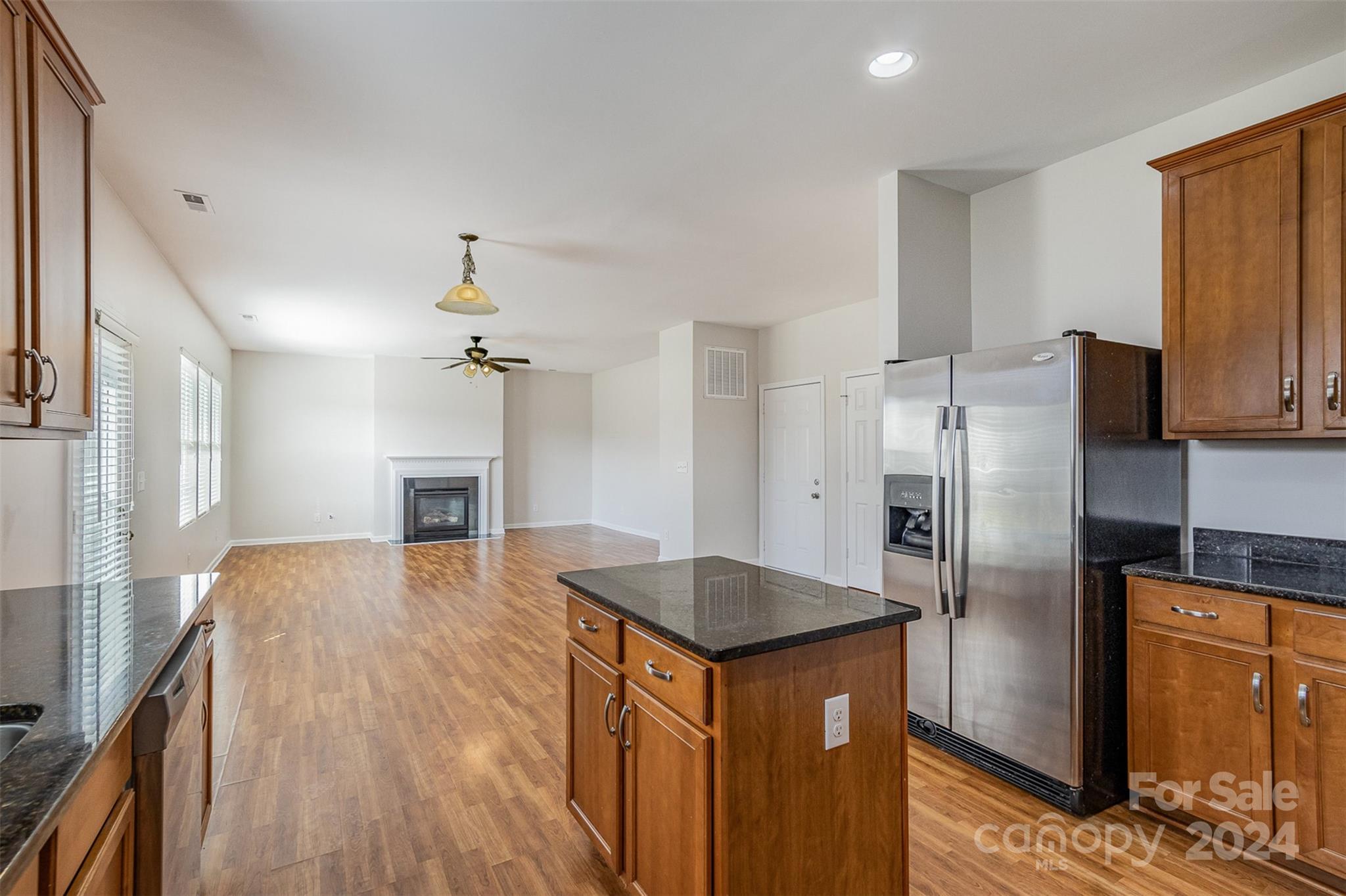7006 Farm Pond Road Indian Trail, NC 28079 - Photo 8 of 37 a kitchen with stainless steel appliances granite countertop a refrigerator a stove and a sink with wooden floor