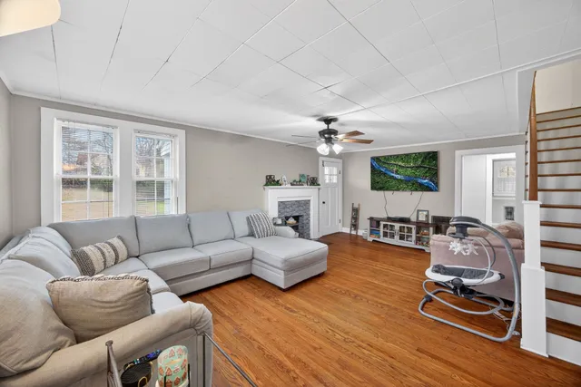 a living room with furniture flat screen tv and window
