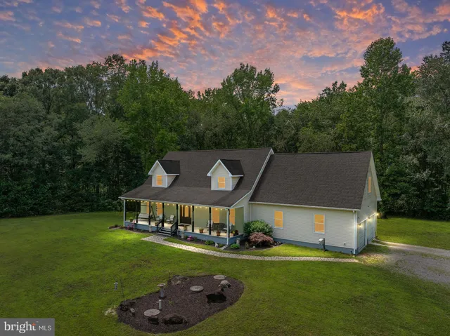a front view of a house with a garden and trees