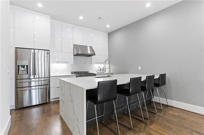 223 16th Street Northwest, Unit 6 Atlanta, GA 30363 - Photo 13 of 32 a kitchen with stainless steel appliances wooden floor and chairs