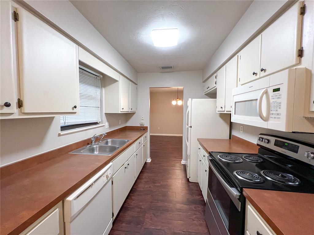 720 Southwest 77th Terrace Gainesville, FL 32607 - Photo 6 of 17 a kitchen with stainless steel appliances granite countertop a stove and a sink