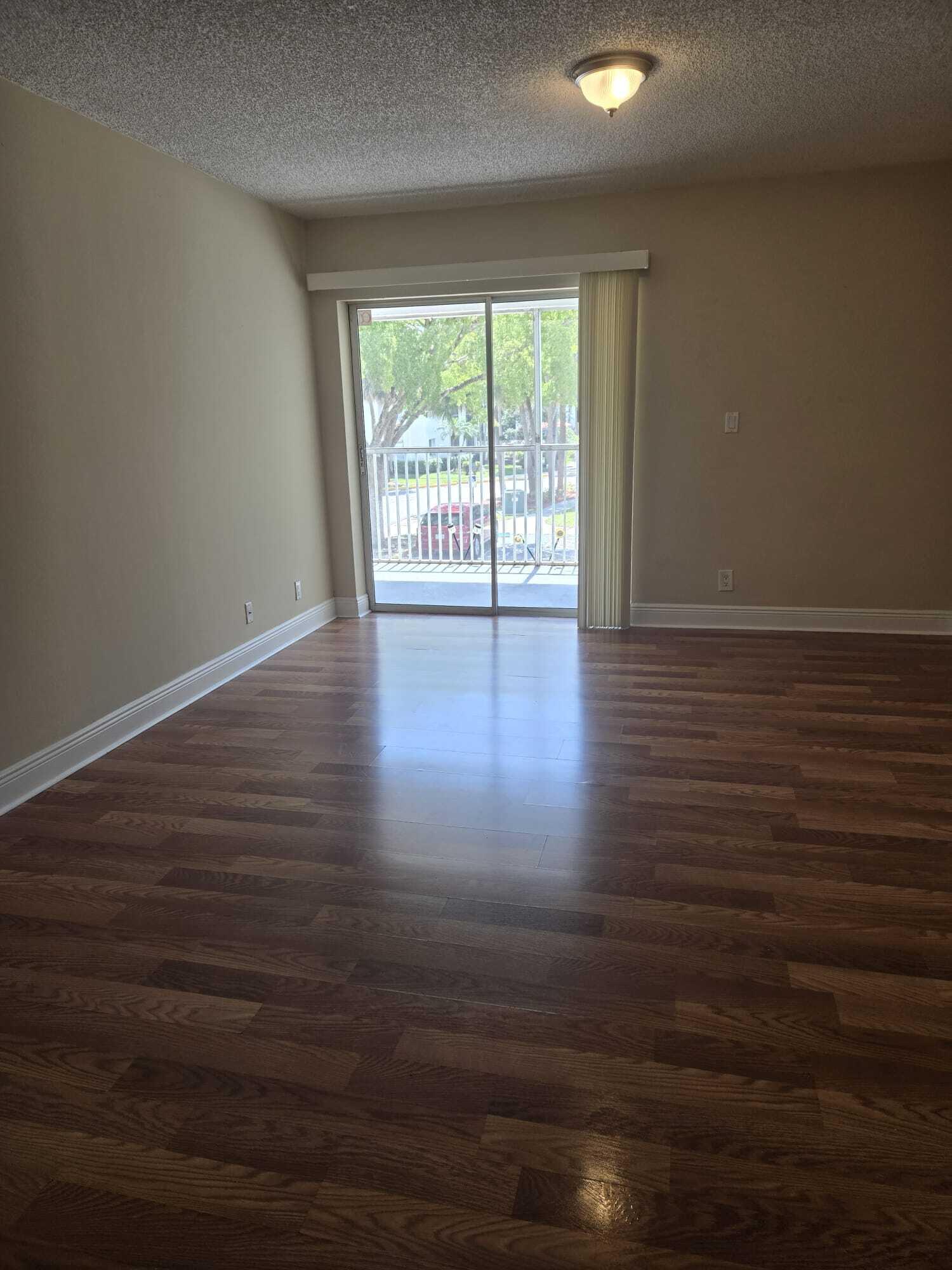 5780 Rock Island Road, Unit 367 Tamarac, FL 33319 - Photo 7 of 13 a view of an empty room with wooden floor and a window