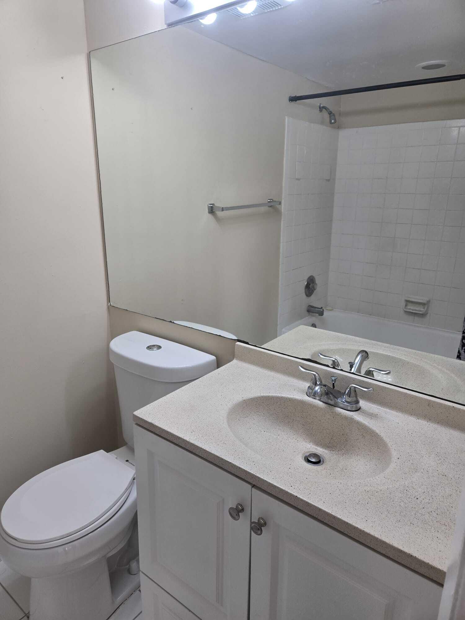 5780 Rock Island Road, Unit 367 Tamarac, FL 33319 - Photo 8 of 13 a bathroom with a sink a toilet and a mirror