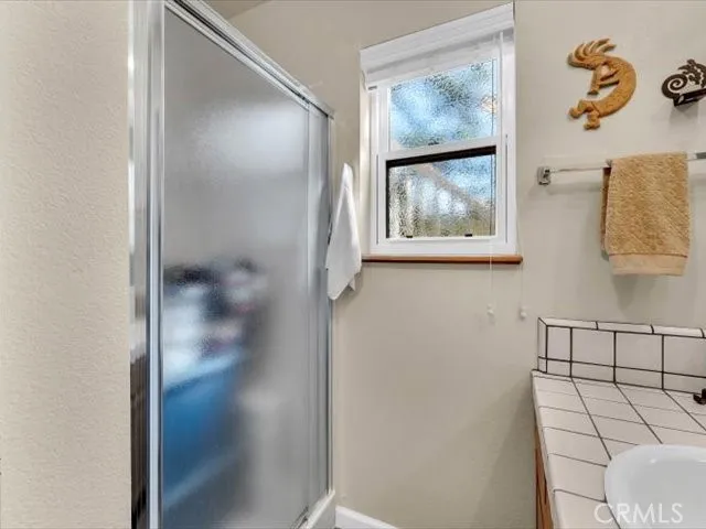 a dining room with wooden floor a chandelier a glass table and chairs
