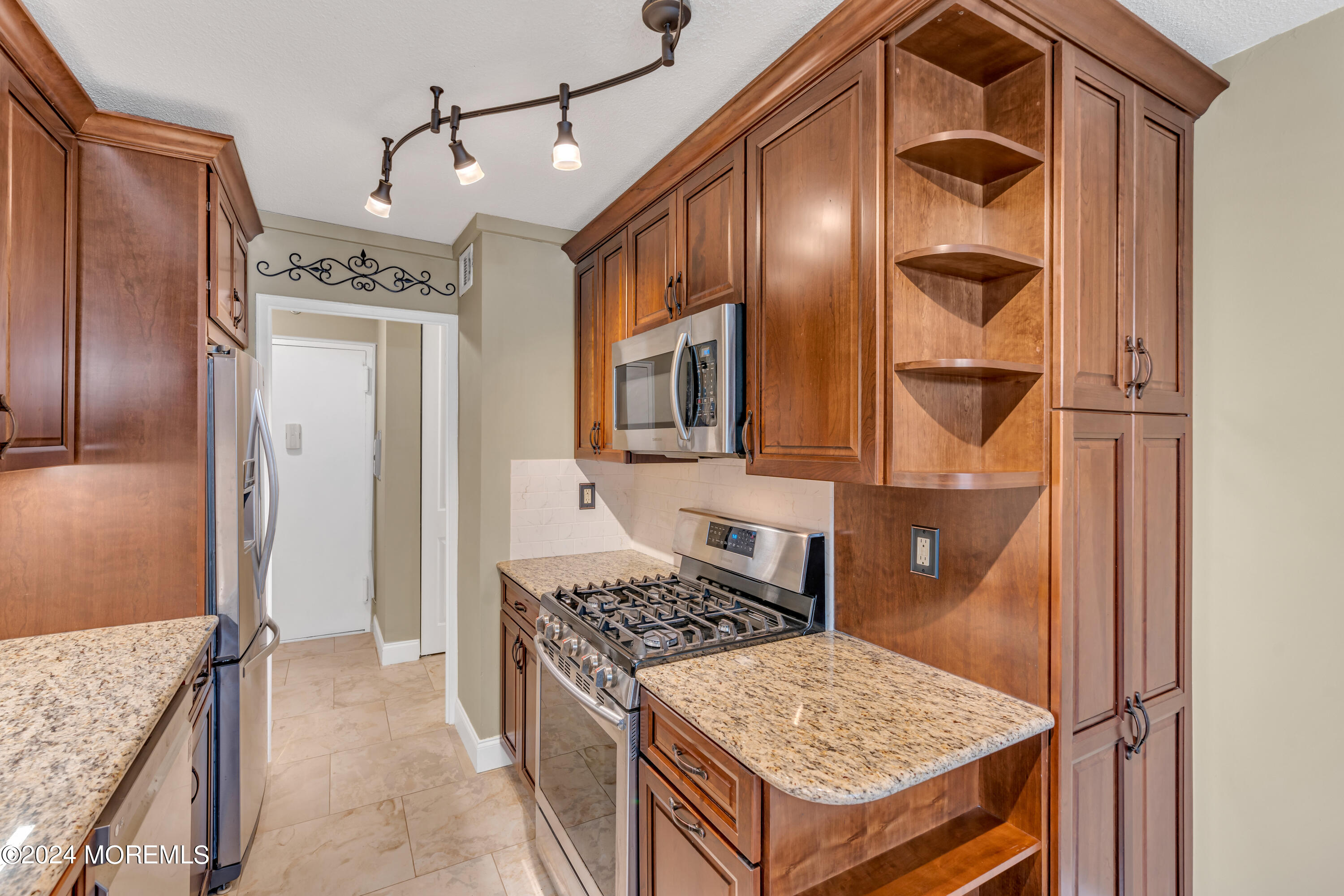 28 Riverside Avenue, Unit 7J Red Bank, NJ 07701 - Photo 10 of 25 a kitchen with stainless steel appliances granite countertop a refrigerator and a stove top oven
