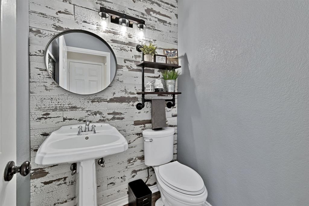 720 Bridget Way Hurst, TX 76054 - Photo 17 of 40 a bathroom with a sink a toilet and a mirror