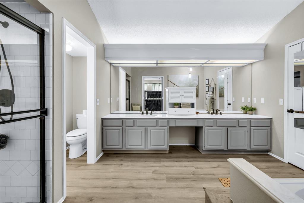 720 Bridget Way Hurst, TX 76054 - Photo 24 of 40 a bathroom with a sink a toilet and a large mirror