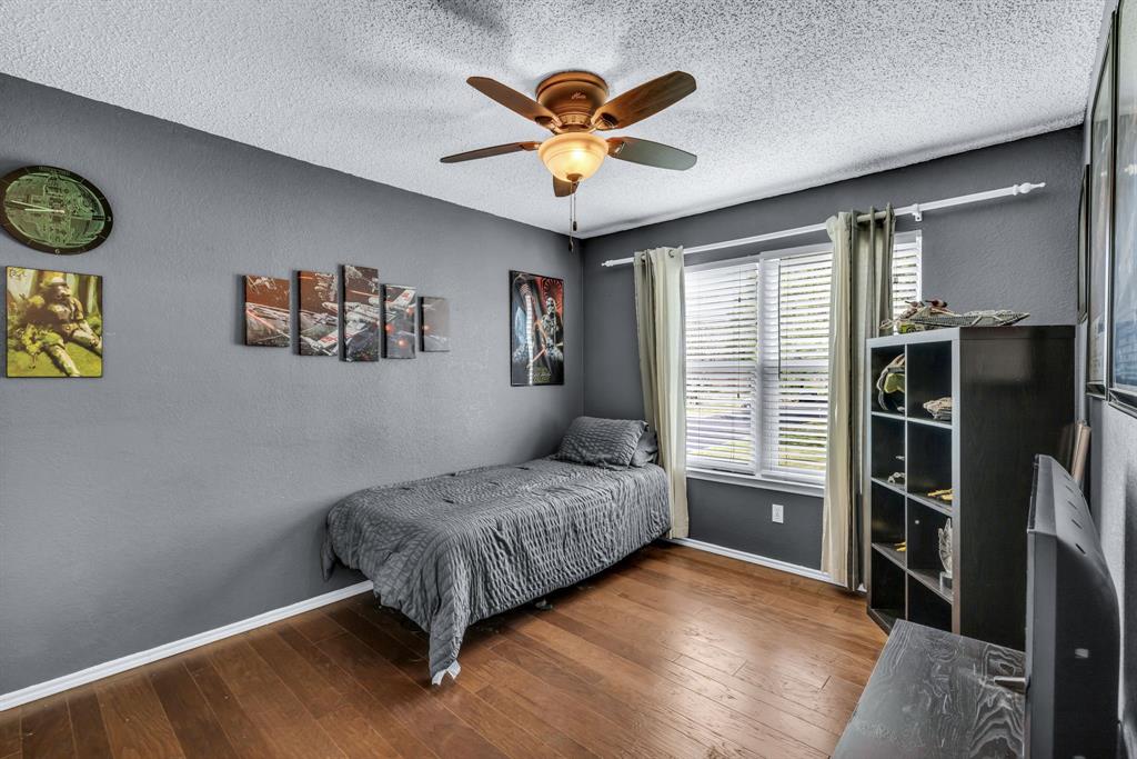 720 Bridget Way Hurst, TX 76054 - Photo 26 of 40 a bedroom with a bed and a chandelier