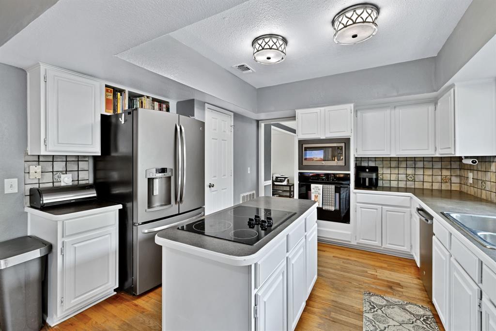 720 Bridget Way Hurst, TX 76054 - Photo 10 of 40 a kitchen with granite countertop a refrigerator a stove and a sink
