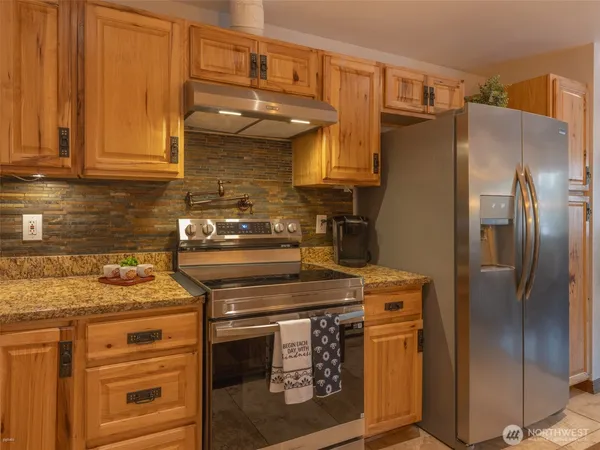 a kitchen with stainless steel appliances granite countertop a stove and a refrigerator