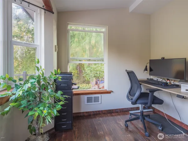 a view of a workspace with furniture and a window