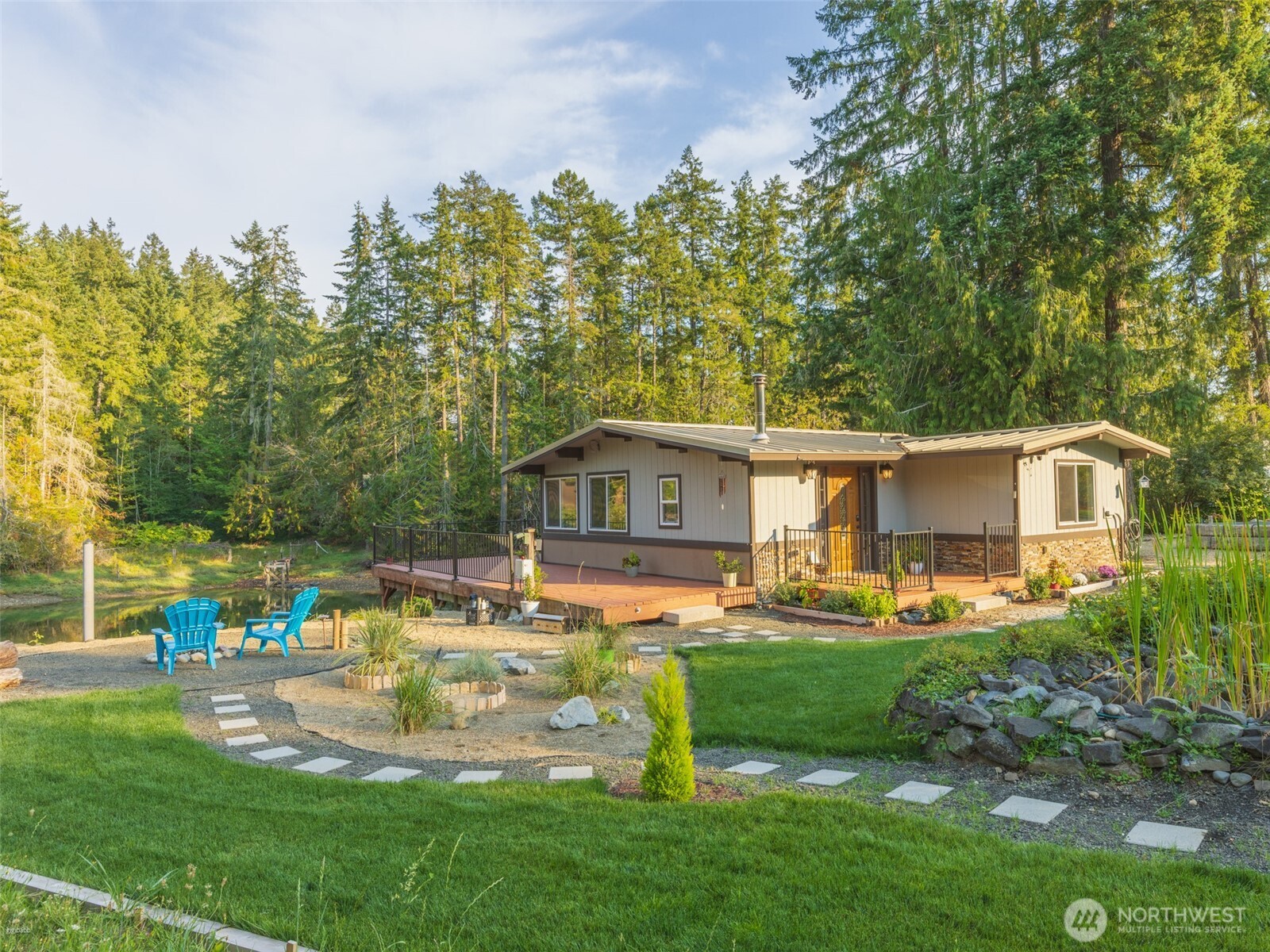 5440 East Grapeview Loop Road Allyn, WA 98524 - Photo 2 of 32 a front view of a house with garden