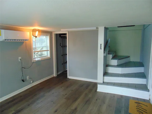 an empty room with wooden floor and closet