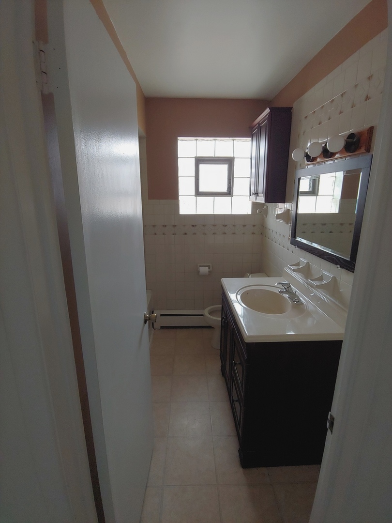 919 Addison Road Addison, IL 60101 - Photo 22 of 24 a bathroom with a sink and mirror