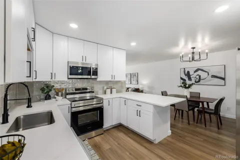 a kitchen with a sink cabinets and wooden floor