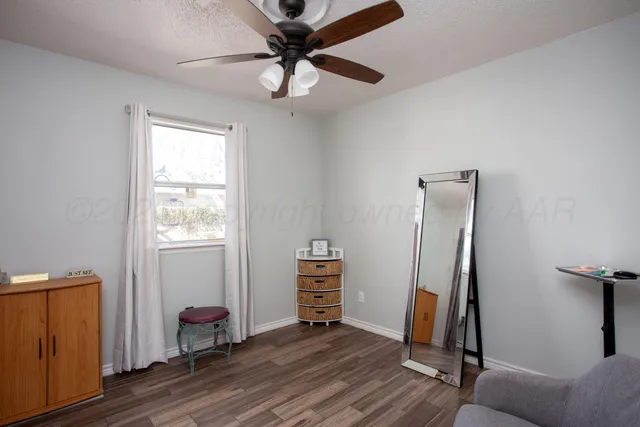 a view of a hallway with wooden floor and furniture