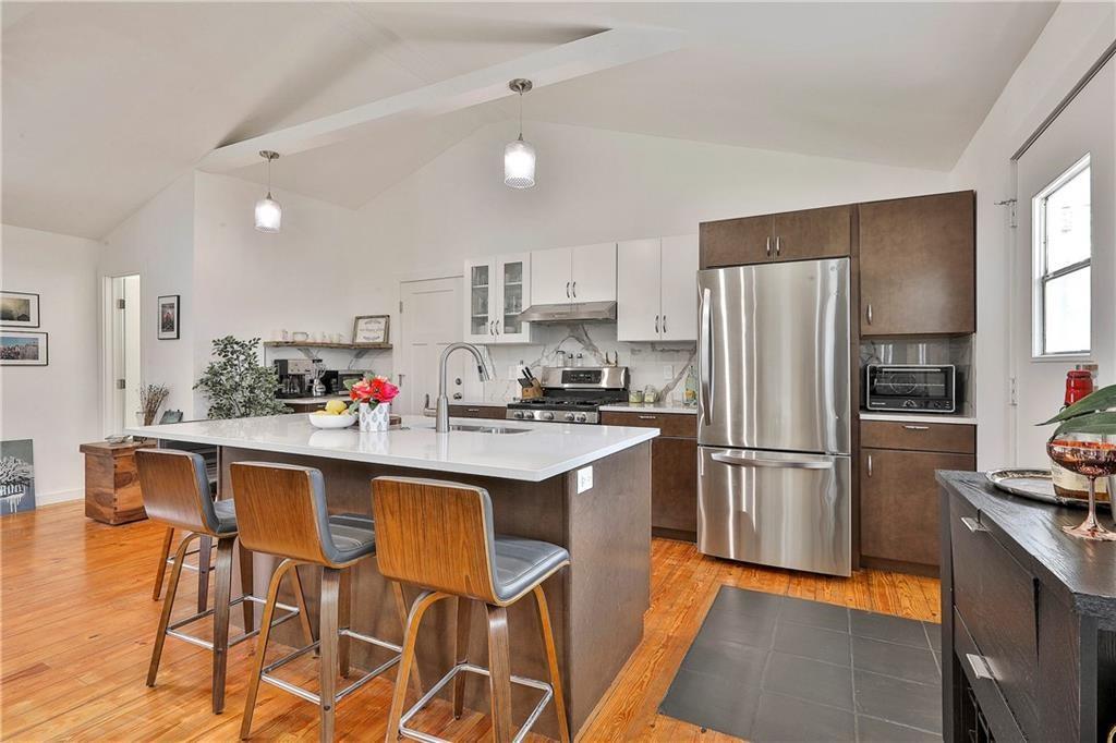2037 A Lively Ridge Road Northeast Atlanta, GA 30329 - Photo 4 of 15 a kitchen with stainless steel appliances a dining table chairs refrigerator and sink