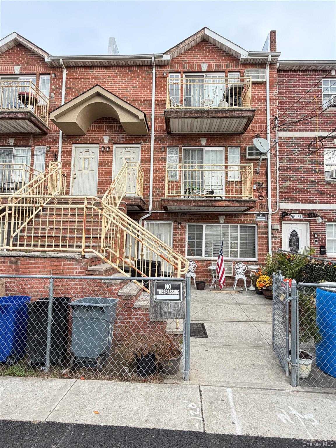 View of front facade featuring brick siding, a fenced front yard, and a gate