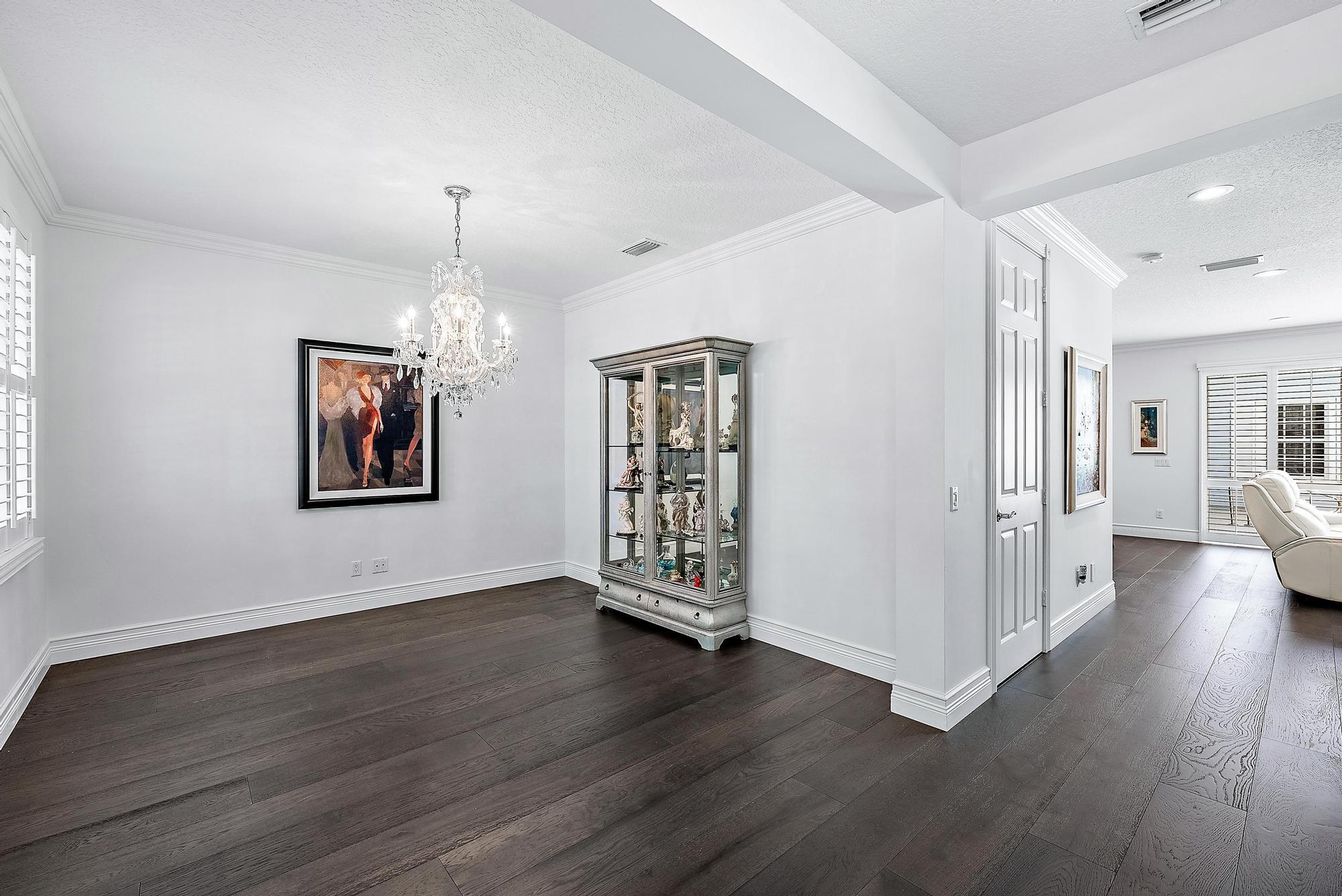 312 Bougainvillea Drive Jupiter, FL 33458 - Photo 13 of 44 an empty room with wooden floor chandelier and windows