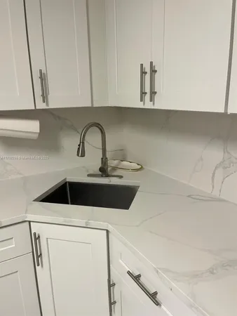 a kitchen with a sink and chairs