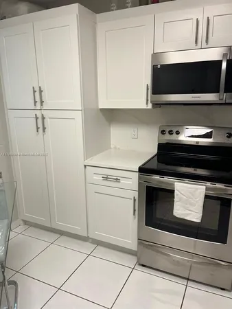 a view of kitchen with microwave stove and cabinets