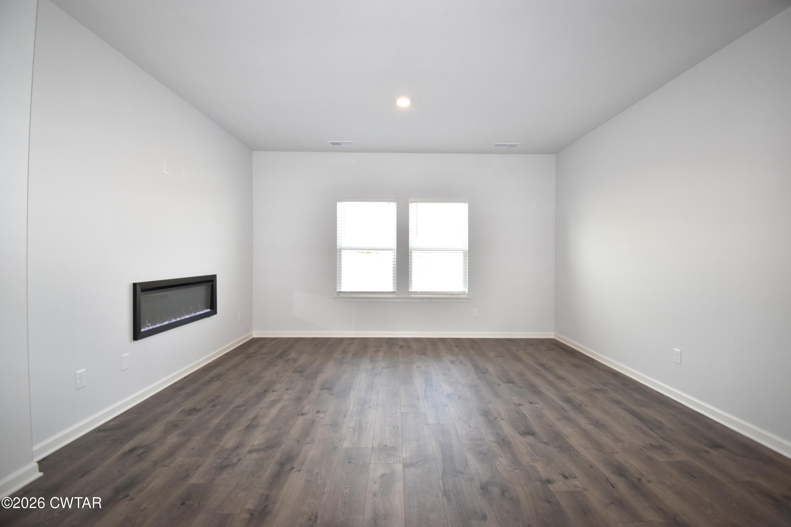 71 Clarendon Cove Jackson, TN 38305 - Photo 2 of 18 an empty room with wooden floor and windows