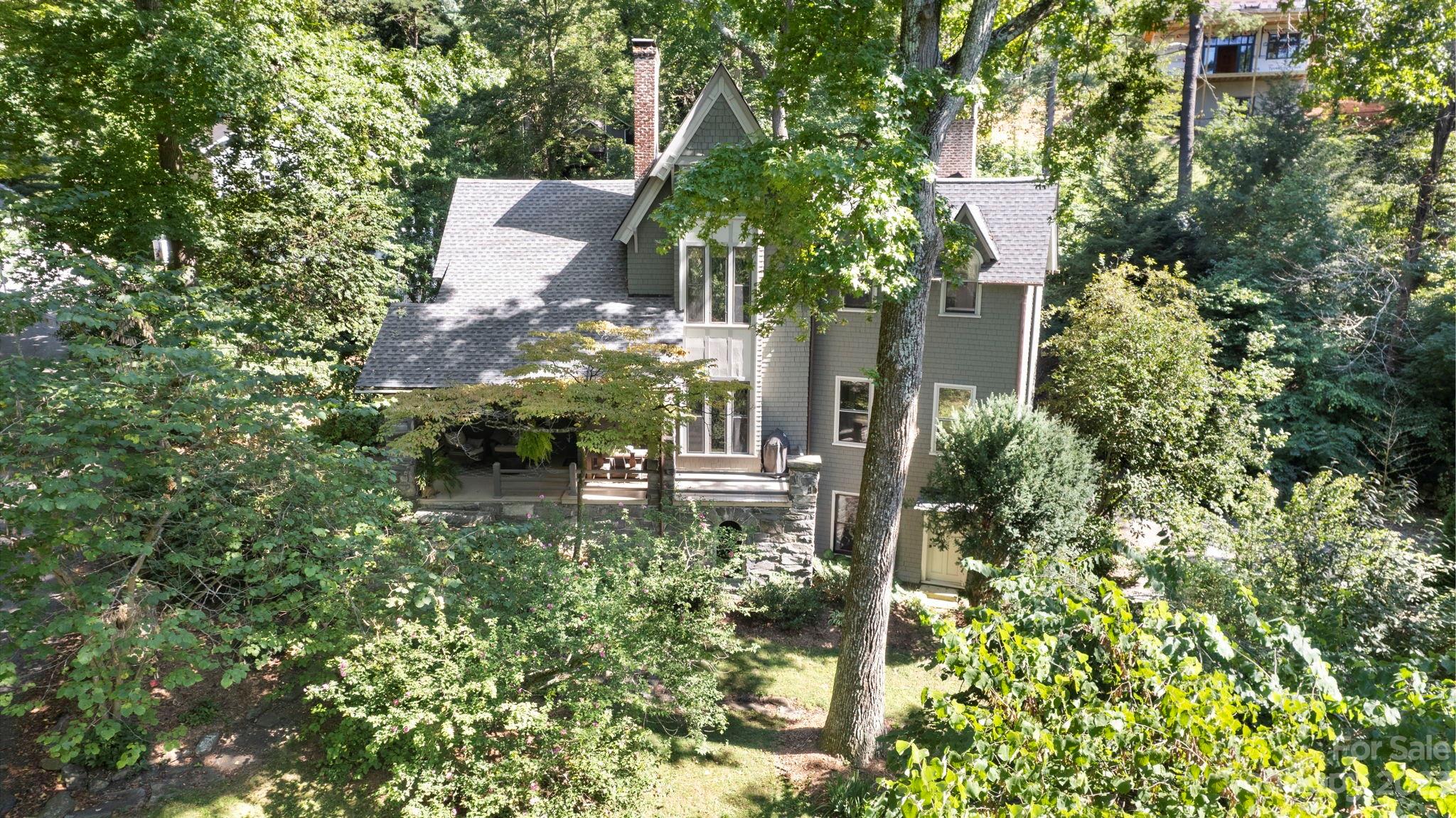 front view of a house with a small yard and potted plants