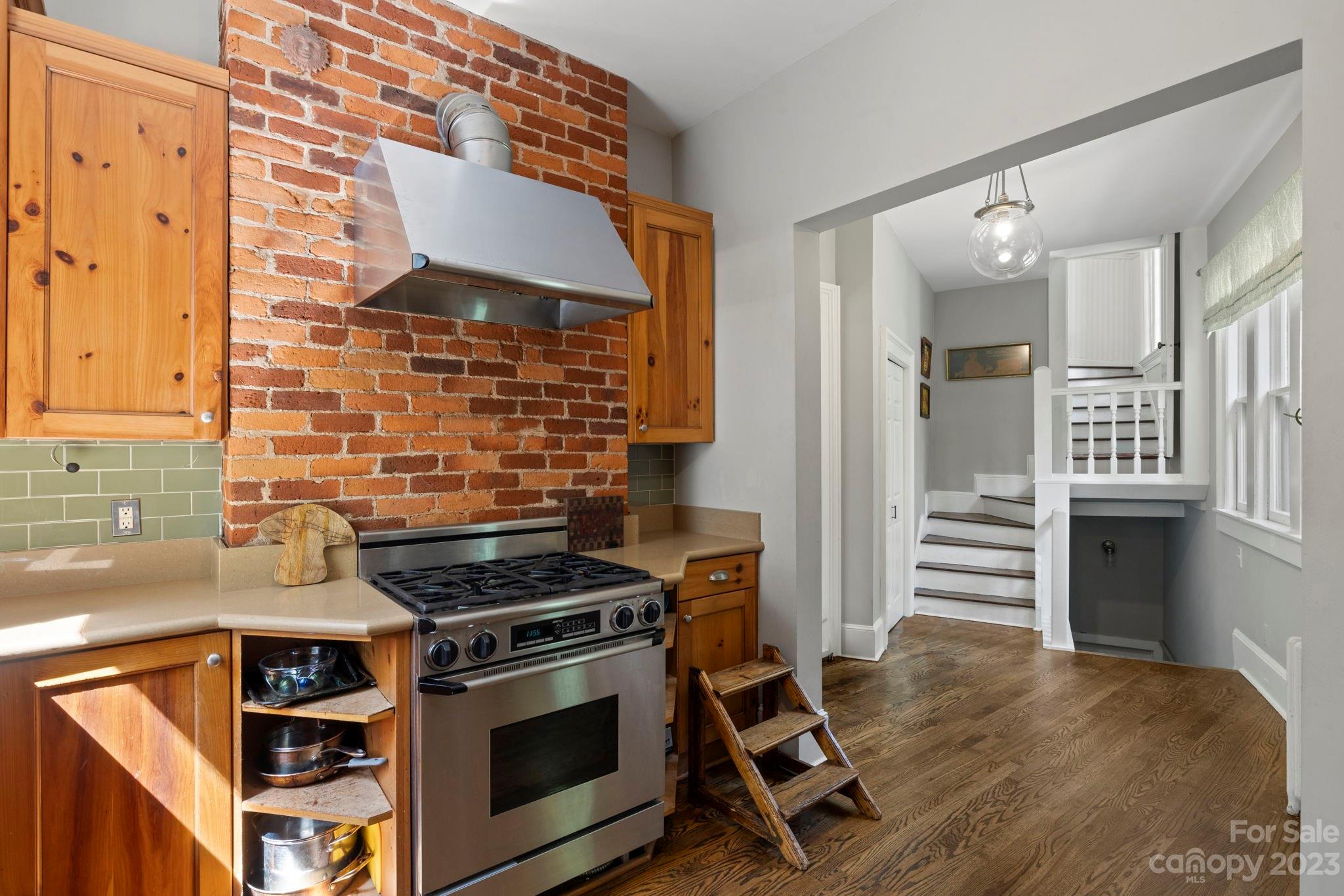 18 Cherokee Road Asheville, NC 28801 - Photo 19 of 45 a kitchen with granite countertop a stove and a refrigerator