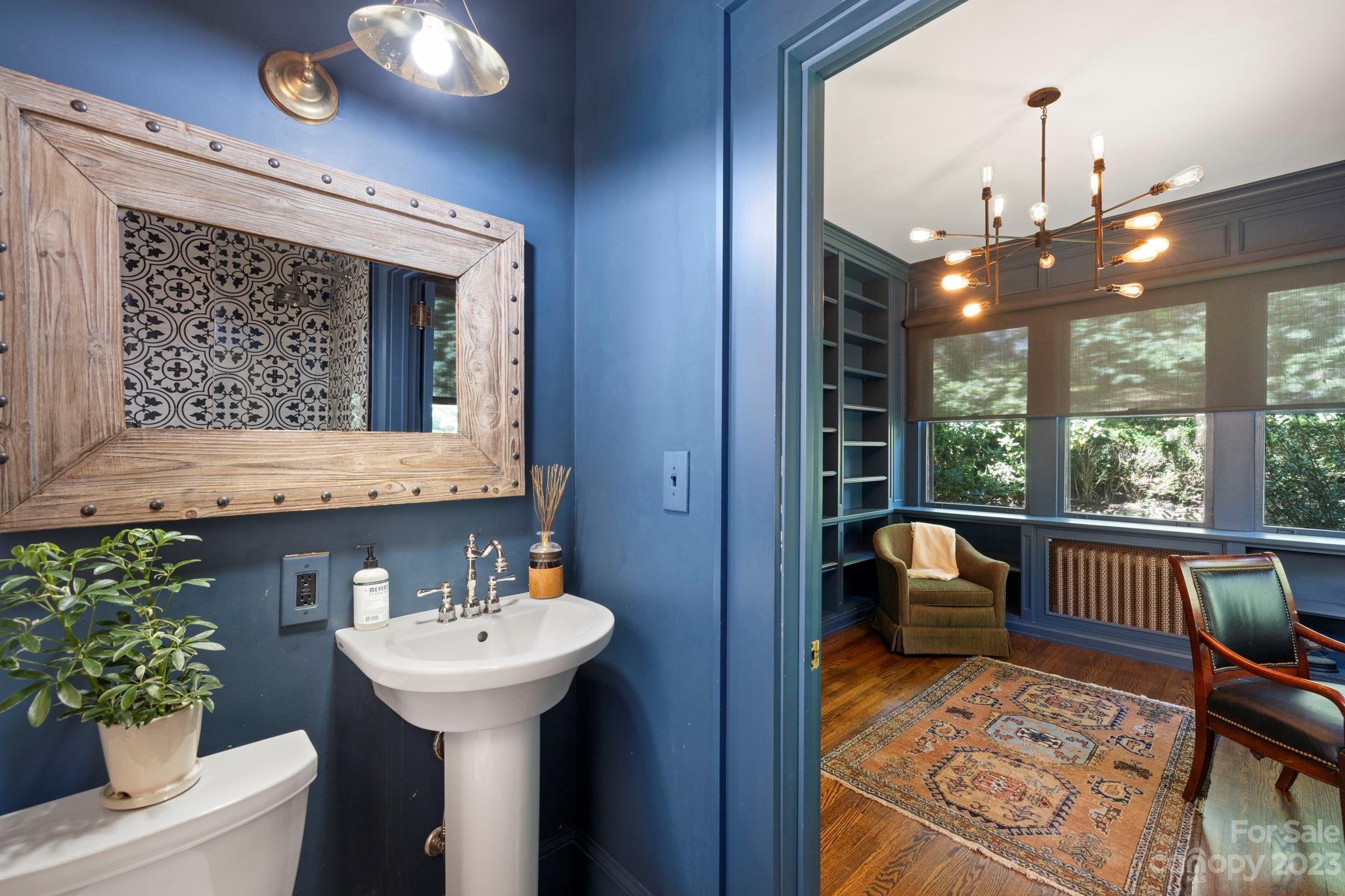 18 Cherokee Road Asheville, NC 28801 - Photo 22 of 45 a bathroom with a sink a large mirror and a potted plant