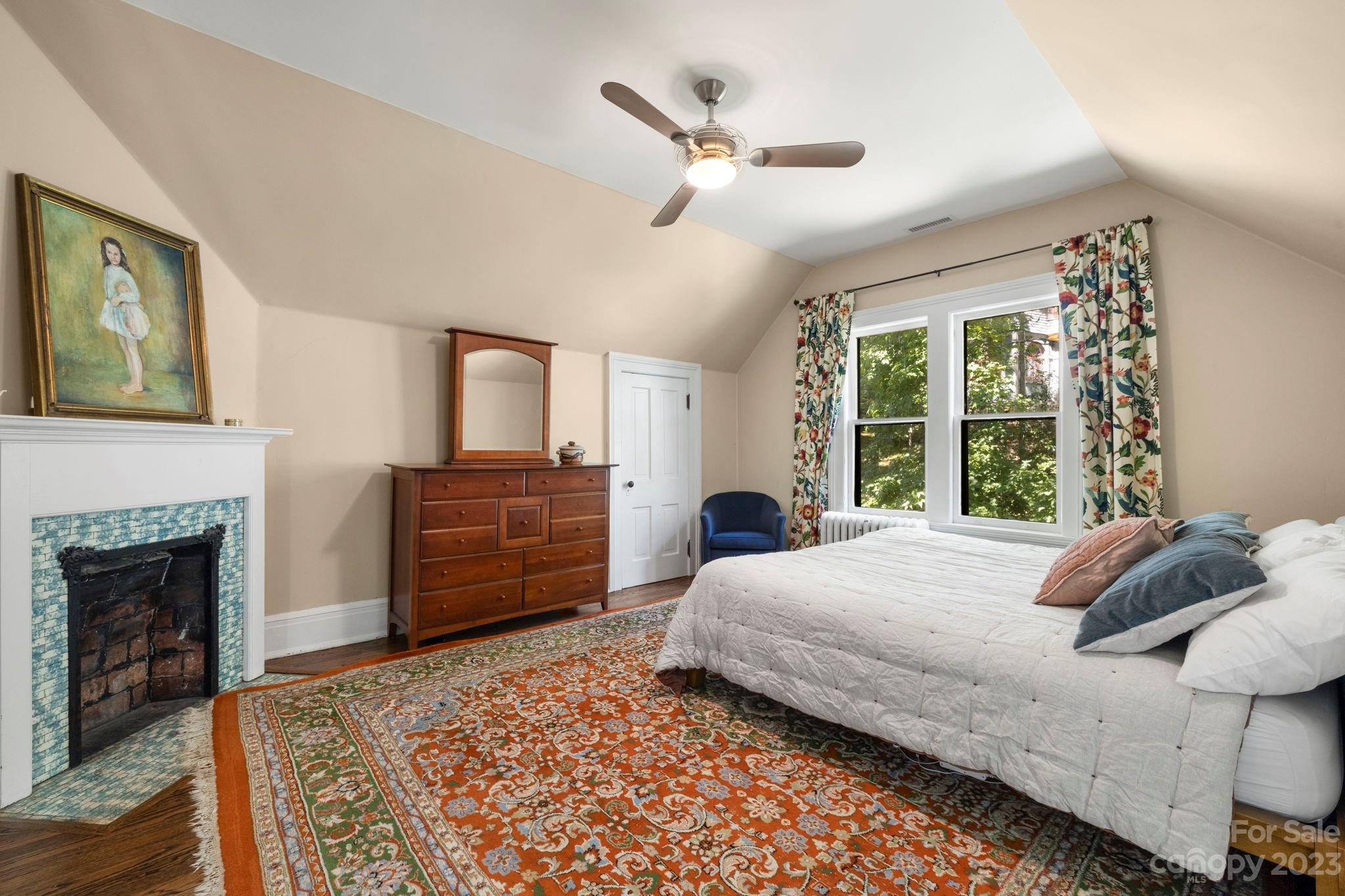 18 Cherokee Road Asheville, NC 28801 - Photo 24 of 45 a bedroom with a bed dresser and a fireplace